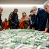 Eine Gruppe von Menschen betrachtet ein architektonisches Modell des Stadtteils.